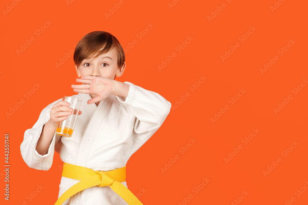 Boy in white kimono drinks water. Healthy sporty childhood and lifestyle. Martial arts, school and training. Boy in white kimono drinks water. Healthy sporty childhood and lifestyle. Martial arts, school and training.