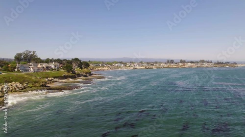Long aerial drone shot of small town along the ocean. 