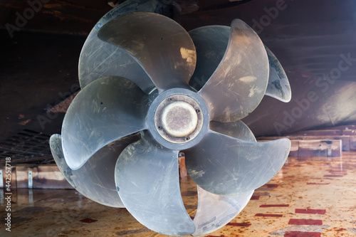 The bottom of a ship supported in dry dock with azimuth propulsion and twin propellers aft.
