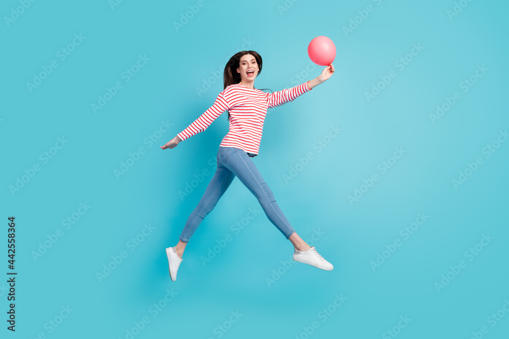 Fototapeta premium Full body profile photo of cool brunette hairdo young lady jump with balloon wear red shirt jeans isolated on blue color background