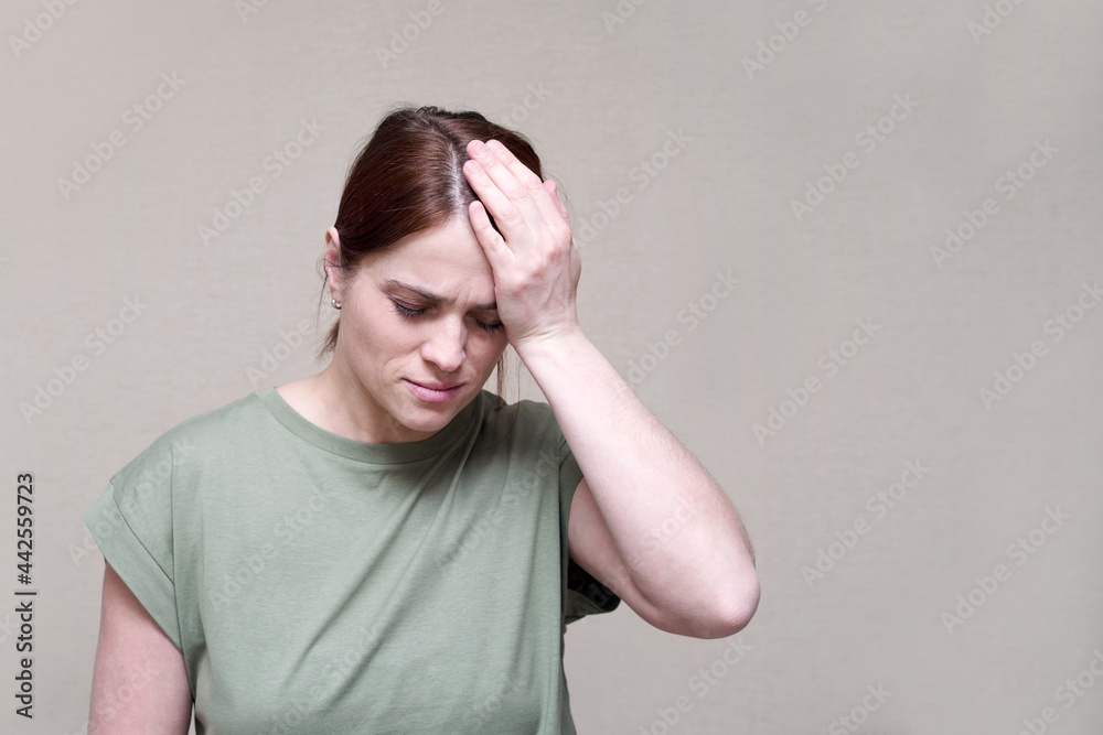 Suffering young woman with closed eyes presses her hand to her head, depicting a headache, migraine. Suffering young woman with closed eyes presses her hand to her head, depicting a headache, migraine.