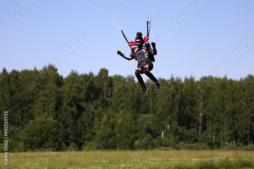 Skydiving. The girl is piloting a parachute and landing.
