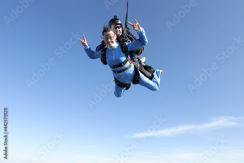 Skydiving. Tandem jump. A barefoot girl is flying in the sky.