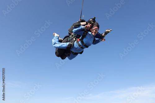 Skydiving. Tandem jump. A barefoot girl is flying in the sky.