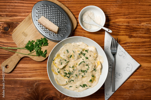 Ravioli with mushrooms, Parmigiano, parsley and fresh basil. Wooden table setup. Close up. Top View