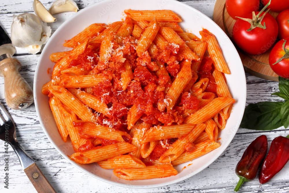 Delizioso piatto di penne pasta italiana con sugo all'arrabbiata. Pomodoro, peperoncino, pancetta ed aglio.