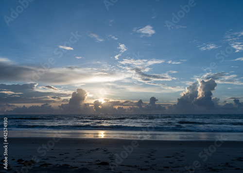 Beautiful sunrise at the beach with pretty clouds and blue sky