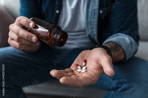 Handful of white pills in male patients palm. Healthcare, treatment, drugs and depression, pain and suicide photo
