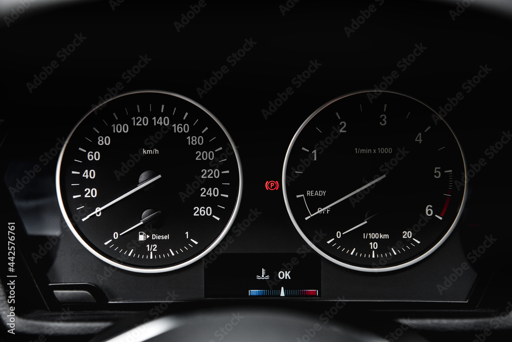 Speedometer arrows in dark colors in a car.