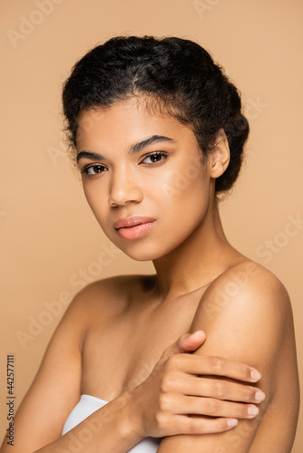 young african american woman with bare shoulders isolated on beige