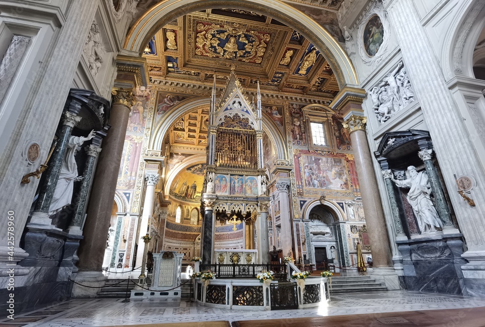 Obraz premium Perspective view of the apse of the Rome cathedral of San Giovanni in Laterano, with the papal altar, the inlaid ceiling and the vault with frescoes.