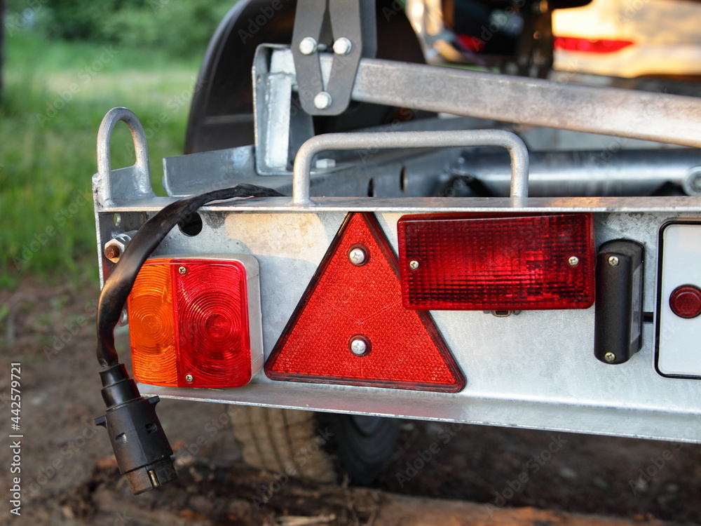 New Russian boat trailer detachable rear bumper panel with tail lights and triangle reflector closeup with disconnected plug cable