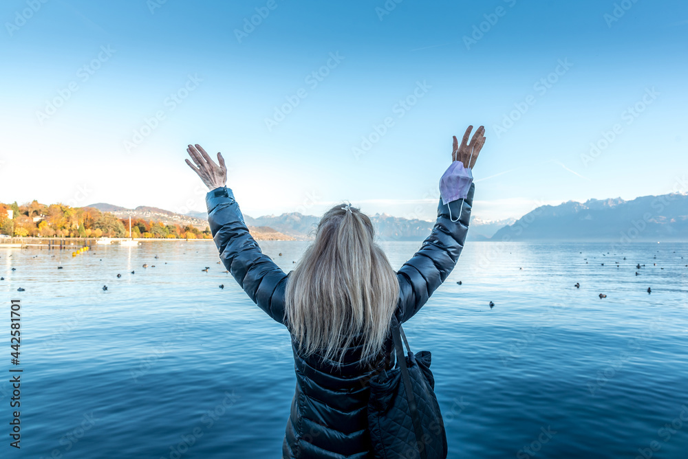 Tourist Woman raising her arms and holding her face mask. Tourist Woman raising her arms and holding her face mask.