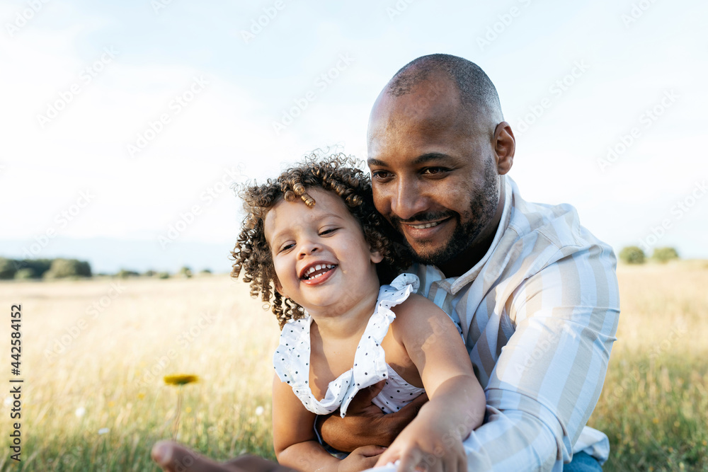 Black father holding cute daughter at sunset Black father holding cute daughter at sunset