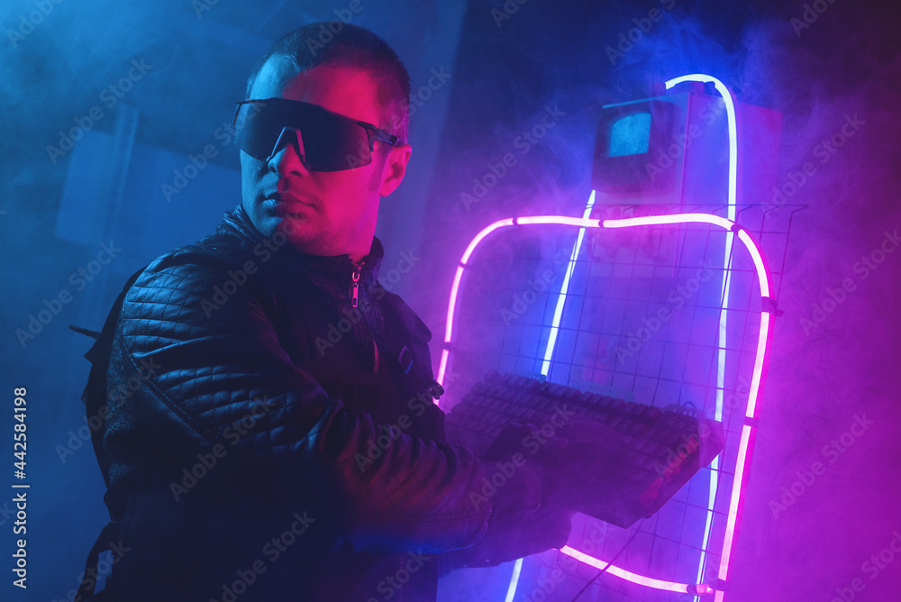 Cyberpunk style man with a computer keyboard in hands in the neon ...