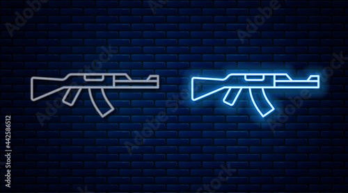 Glowing neon line Submachine gun icon isolated on brick wall background. Kalashnikov or AK47. Vector