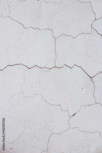 Close up of textured cracked vertical white old wall background. Copy space option