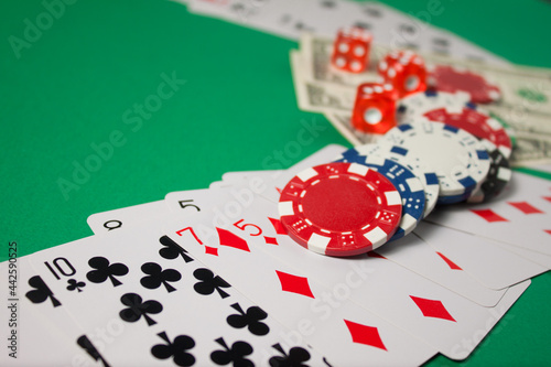 Classic playing cards, chips, red dice and dollars on green background with place for text. Gambling and casino concept.