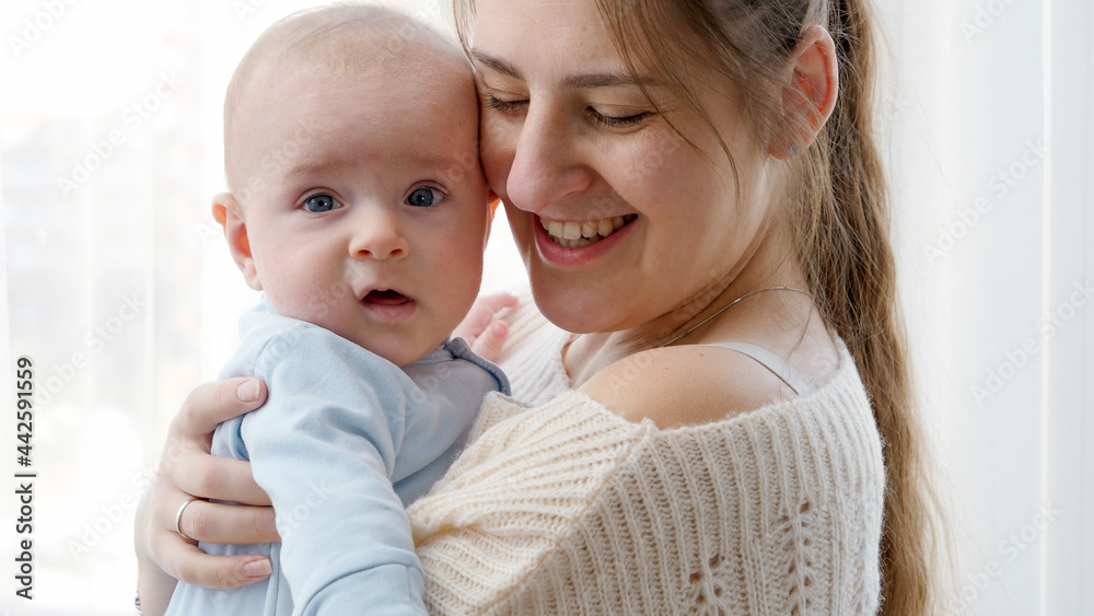 Portrait of happy smiling mother hugging her little baby son with blue eyes Portrait of happy smiling mother hugging her little baby son with blue eyes