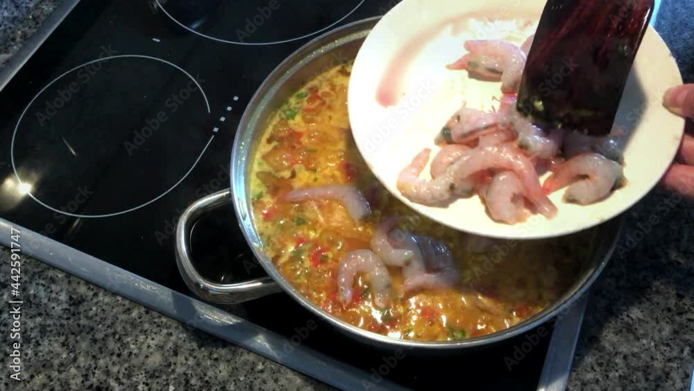 Cooking rice with prawns and tuna. Typical Spanish food paella