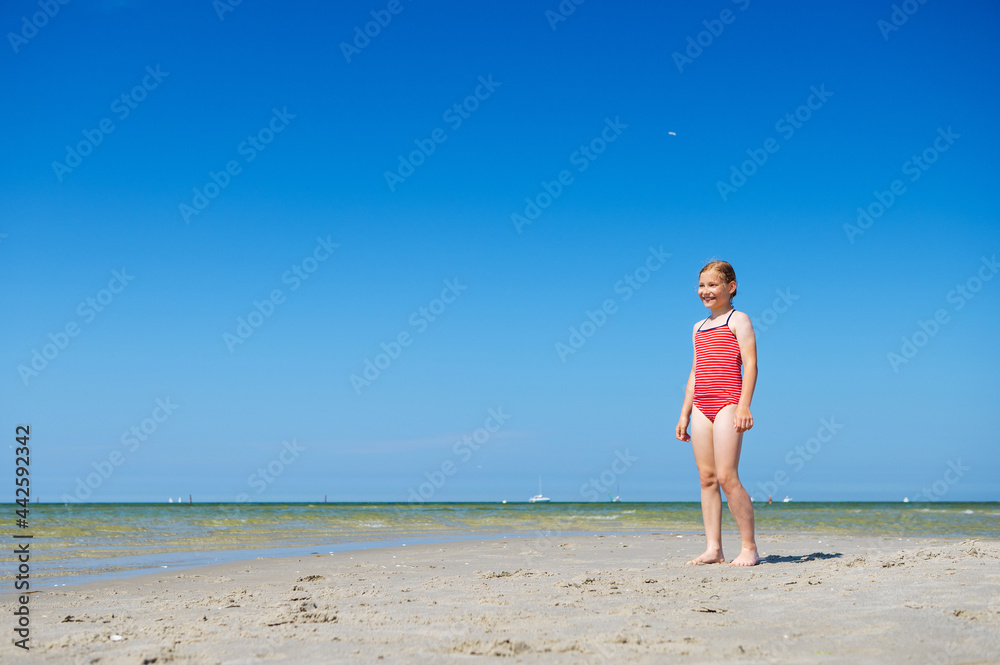 Cute child girl running and having fun on beach at summer day Cute child girl running and having fun on beach at summer day