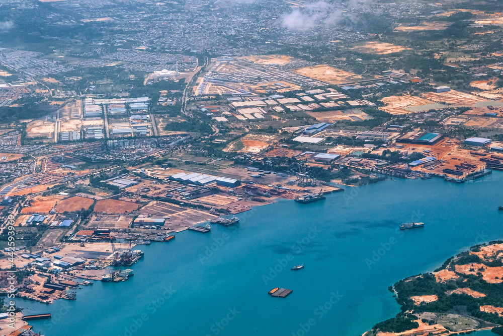 Aerial view of coastal construction or port areas in Strait of Malacca, on airplane route to Malaysia or Singapore. Airplane shot