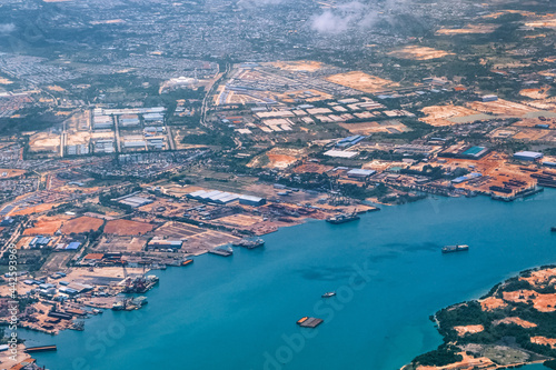Obraz na płótnie Aerial view of coastal construction or port areas in Strait of Malacca, on airplane route to Malaysia or Singapore. Airplane shot w salonie