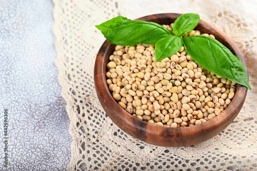 Fototapeta premium Soybeans in wooden bowl on light background