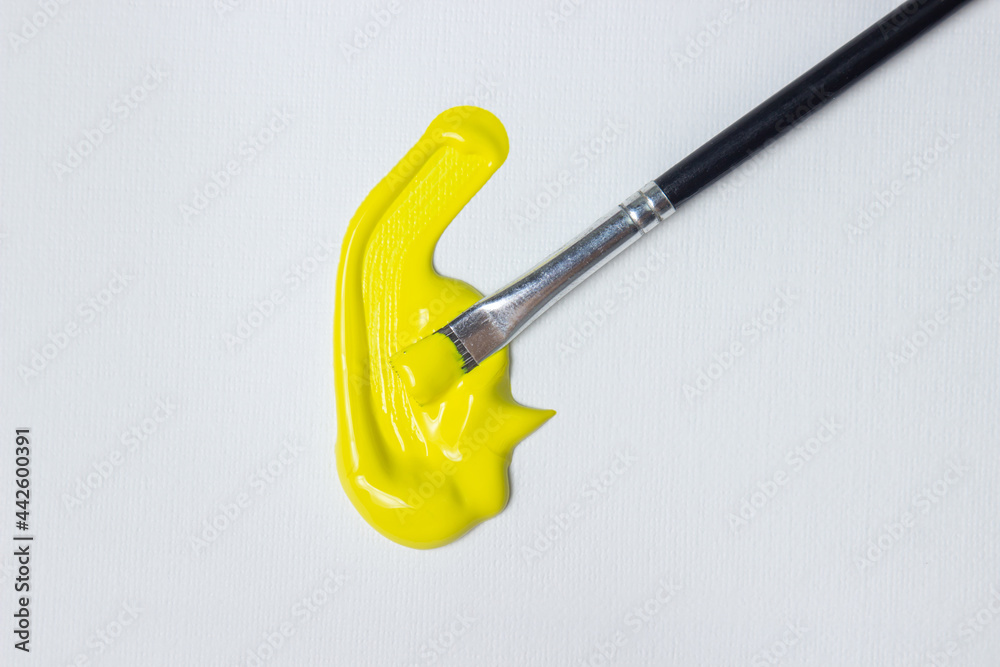 Brush for painting with yellow paint on a white background. Watercolor paint Brush for painting with yellow paint on a white background. Watercolor paint