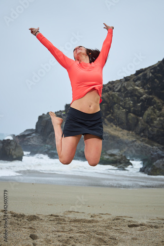  woman jumping of happiness with arms up in symbol of freedom