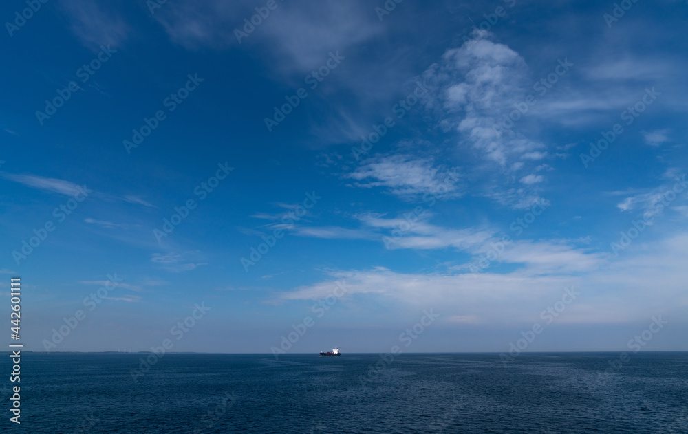 large freight ship travelling full steam ahead and approaching from far away on the open ocean