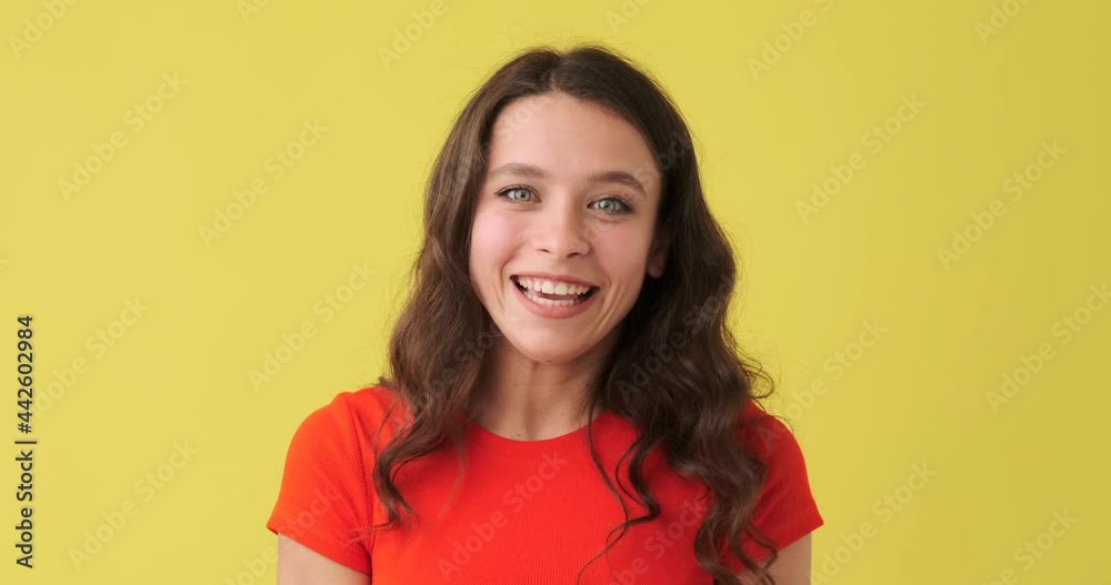 Happy woman greeting and explaining over yellow background Happy woman greeting and explaining over yellow background