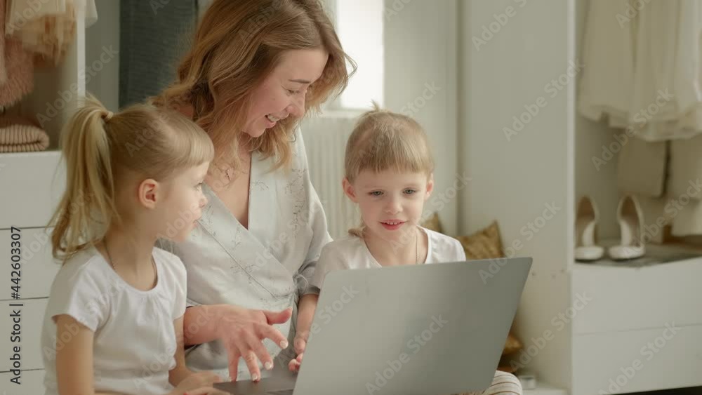 mom with daughters blonde twins sitting at a laptop mom with daughters blonde twins sitting at a laptop