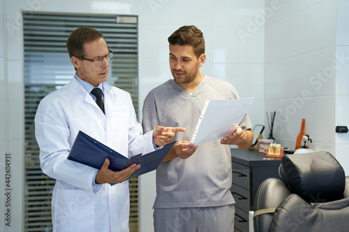 Dentist and his trainee having a conversation at the office