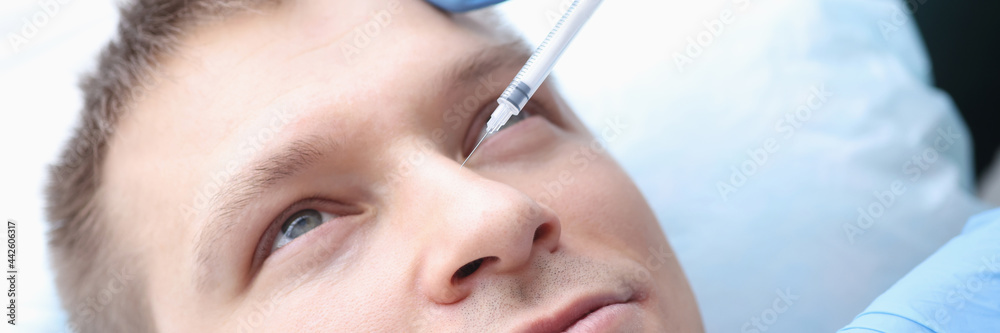 Young man is given rejuvenating injection in face