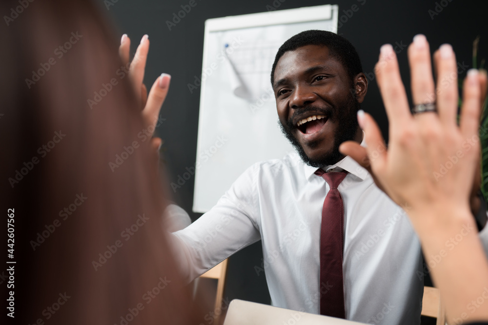 Fototapeta premium Happy african american businessman in shirt smiling and giving five to woman
