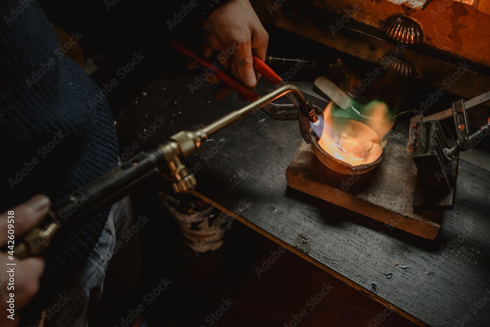 Crop jeweler melting metal with torch Crop jeweler melting metal with torch