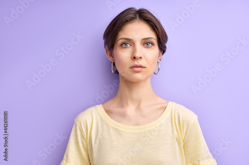 Canvas Print confident short haired woman looking seriously, isolated portrait on purple background