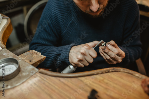 Crop goldsmith polishing ring photo