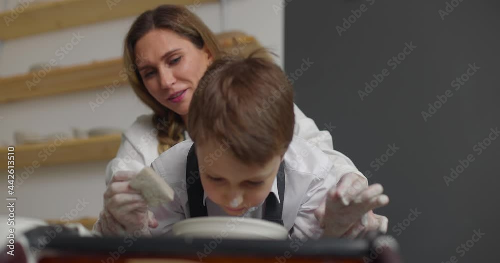 Mother and son doing pottery together in studio. Slow motion Mother and son doing pottery together in studio. Slow motion