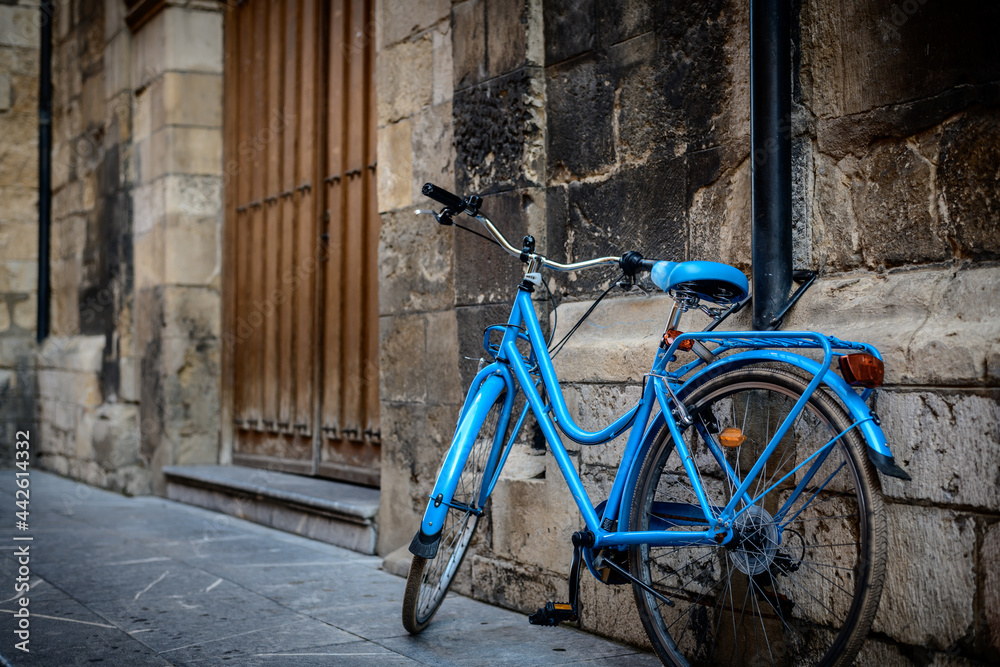 blue bicycle leaning against the wall of an old church