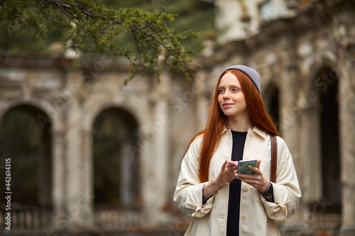 Photography Beautiful caucasian woman walking in historical places at morning, using smartphone