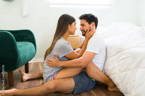 Latin couple cuddling in the bedroom floor