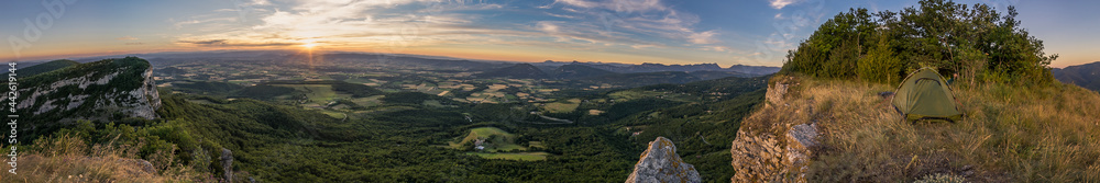 Panorama of wide landscape in Provence with fields and tent at hill top at sunset from viewpoint near Eyzahut, France