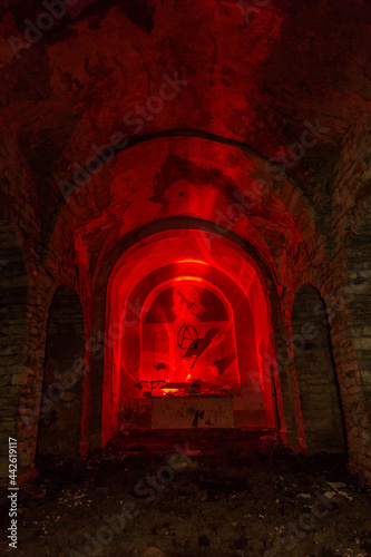 inside abandoned dark church in spain illuminated with red light