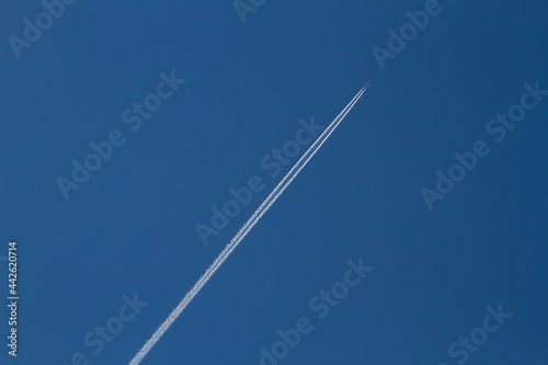 Air Plane Contrails in a clear blue sky Travelling some where.