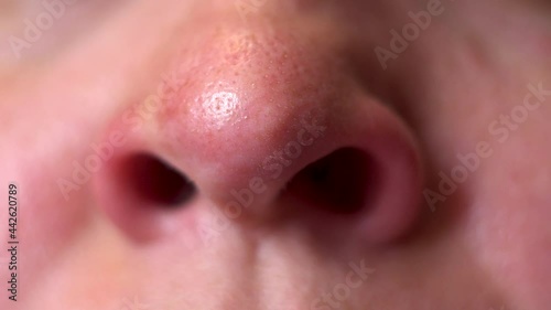 Nasal breathing. Woman's face. Movement of the nostrils. Inhalation of air. Part of the face. Big nose. A sick man. Oxygen breathing. Macro. Close-up.