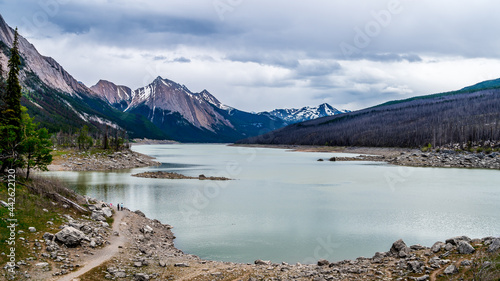 Fototapeta Naklejka Na Ścianę i Meble -  Medicine Lake in Jasper National Park in the Canadian Rockies under Dark Clouds. The lake fills and empties annually as the water drains through an underground drainage system