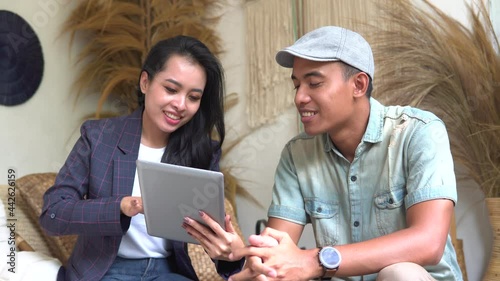 portratit of Craft business owner and client use tablet together while meeting in the store photo