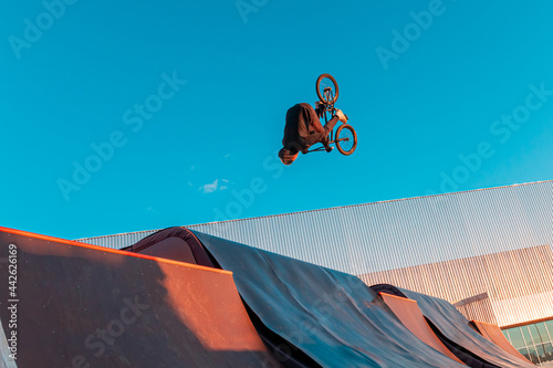 Bmx rider doing trick on ramp in skate park